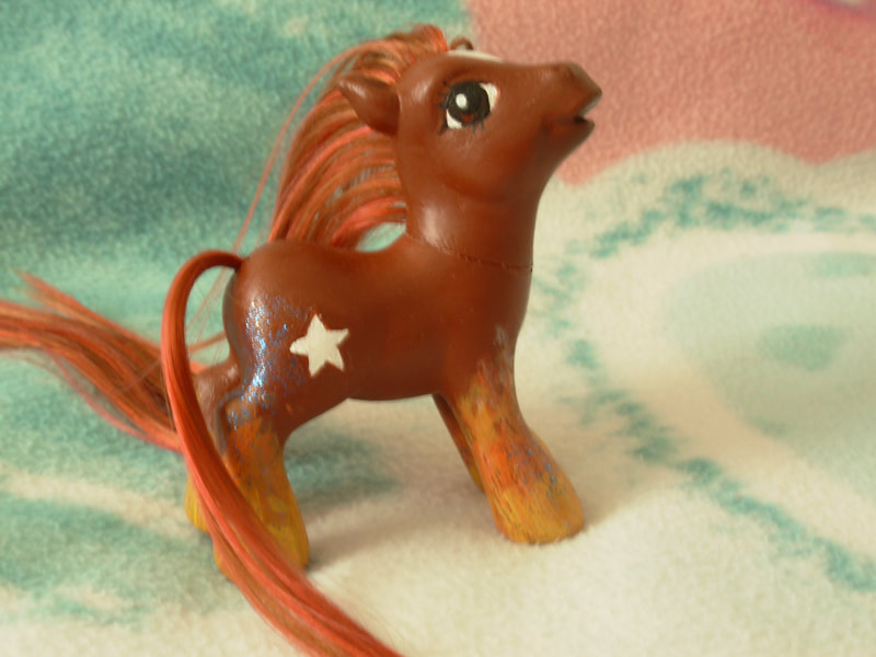 A brown G3 MLP with brown and natural red mane/tail, a white star on her forehead, brown eyes, firey hooves and a shooting star cutie mark