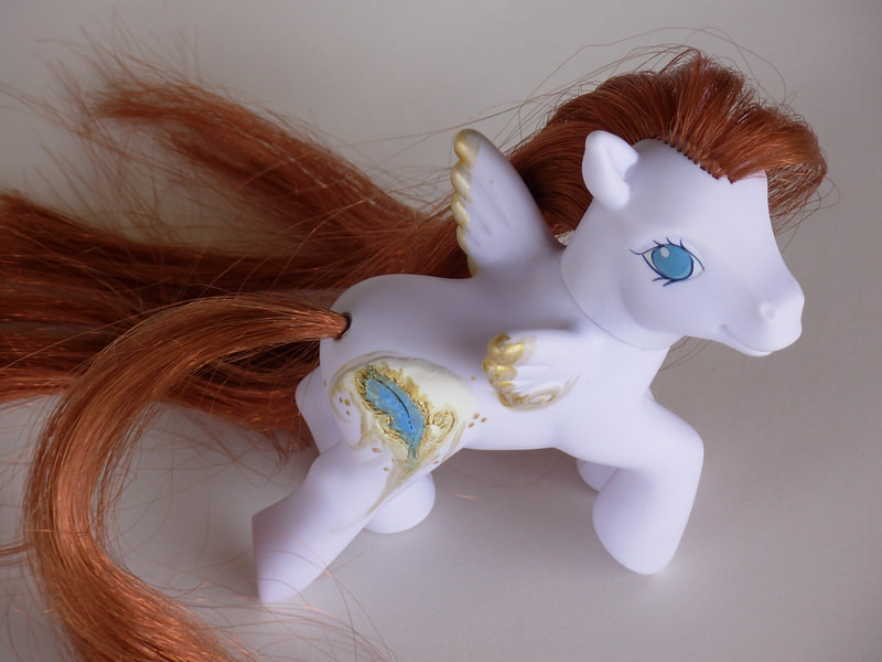 A white G3 pegasus MLP with brown mane/tail, blue eyes and a 3D sculpted blue feather cutie mark
