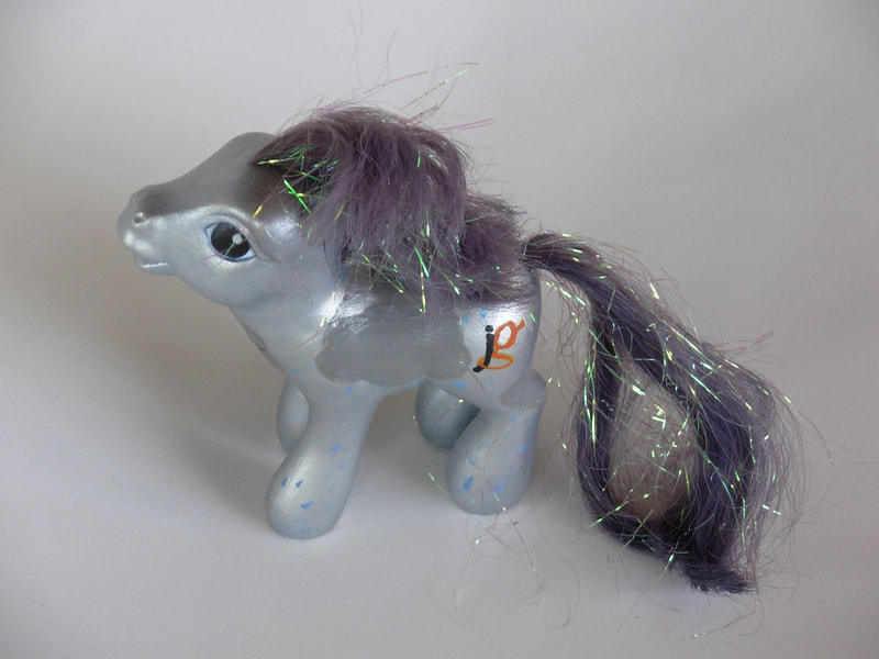 A silver G3 MLP with gray rainclouds, dark blue eyes, a dyed mane and tail, and the Josh Groban initials logo as the pony's cutie mark